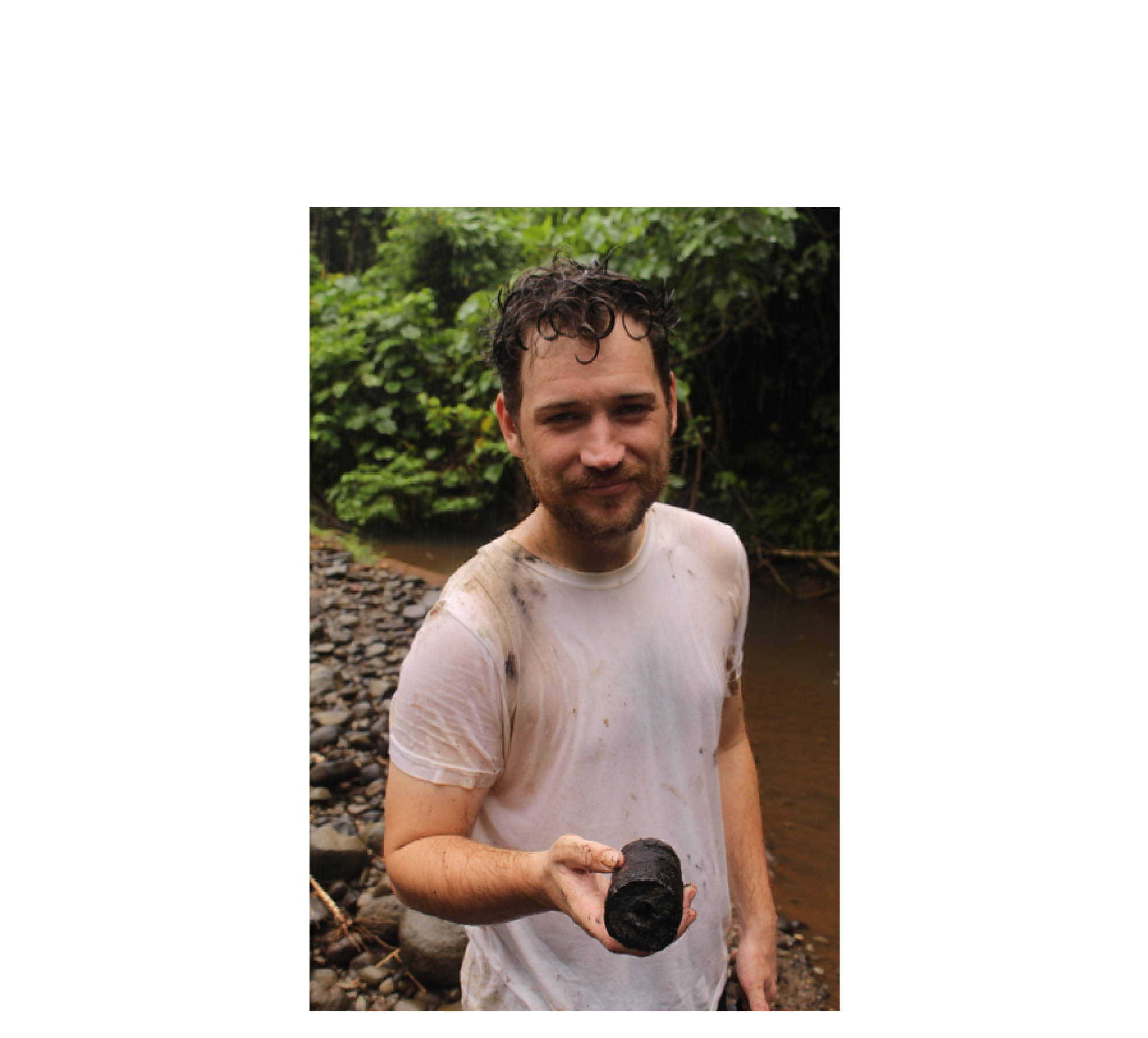 A damp Robert Henderson holding a carbonised branch associated with the Kuwae eruption on Epi Island some 50kms from the crater. The perfect dating material