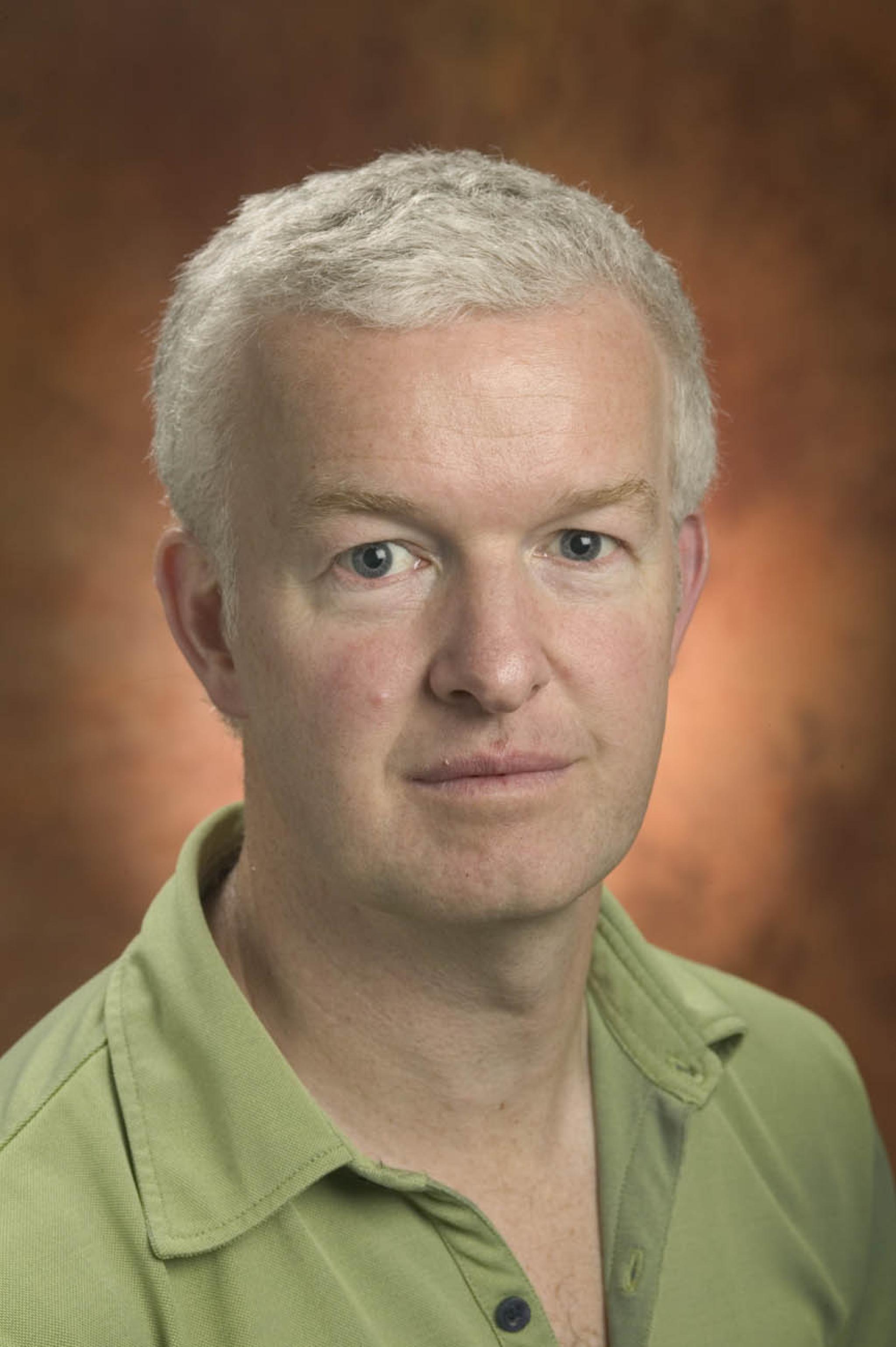 Headshot of Chris Ballard in a green collared shirt looking at camera