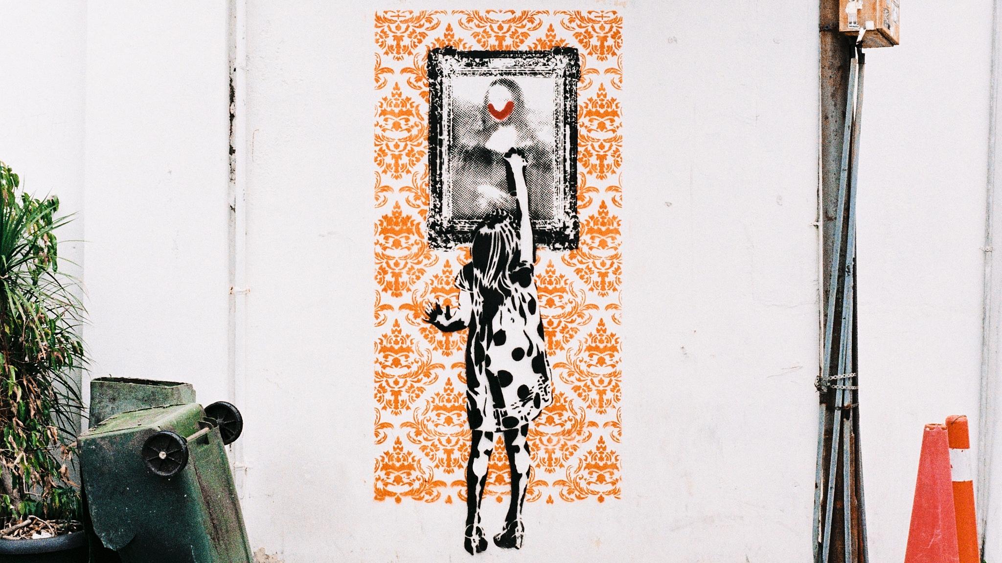 A mural in Penang depicts a young girl spray-painting the Mona Lisa on an unassuming neighbourhood wall