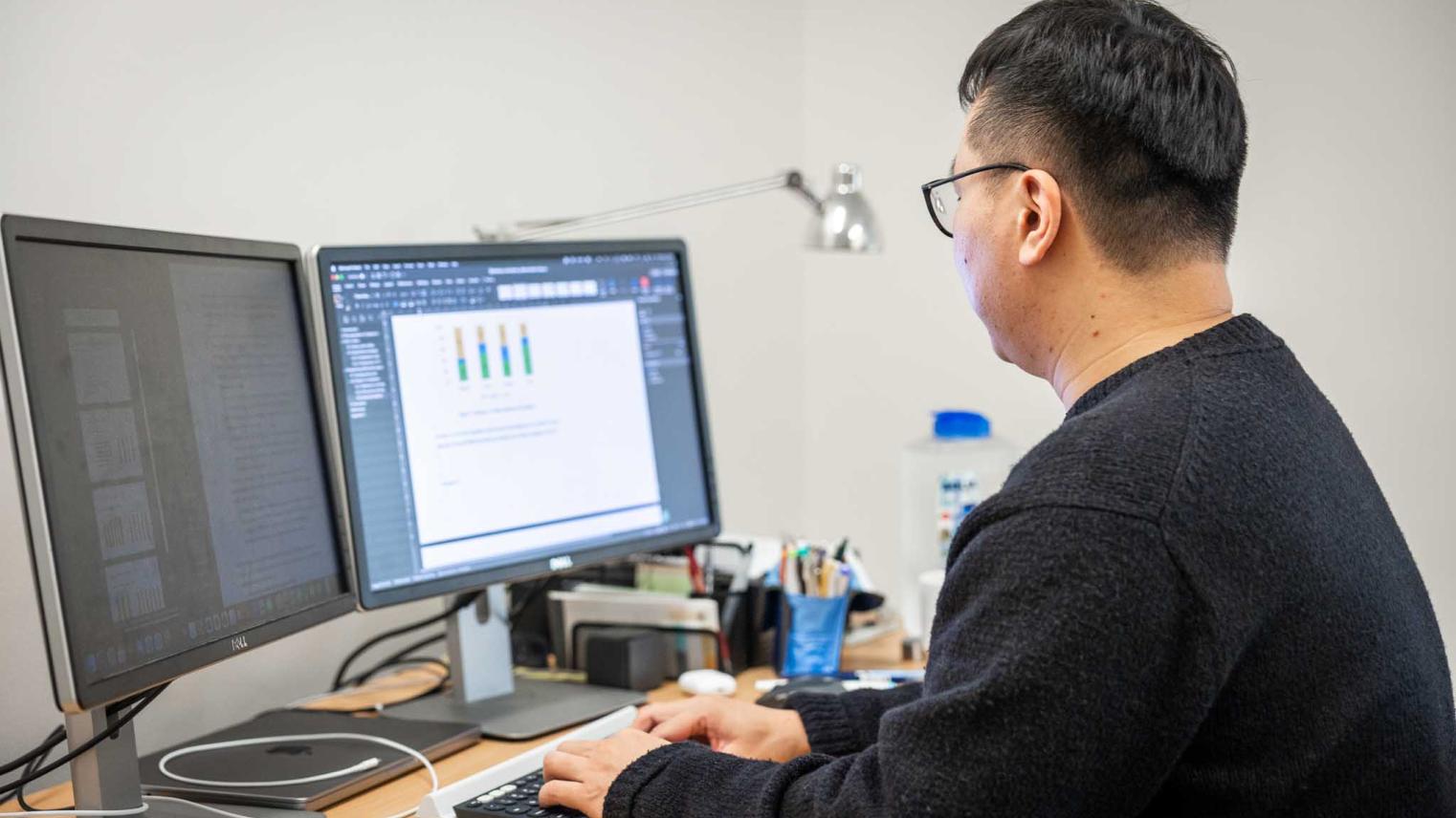PhD candidate Huade Huang sits in his office undertaking his research.